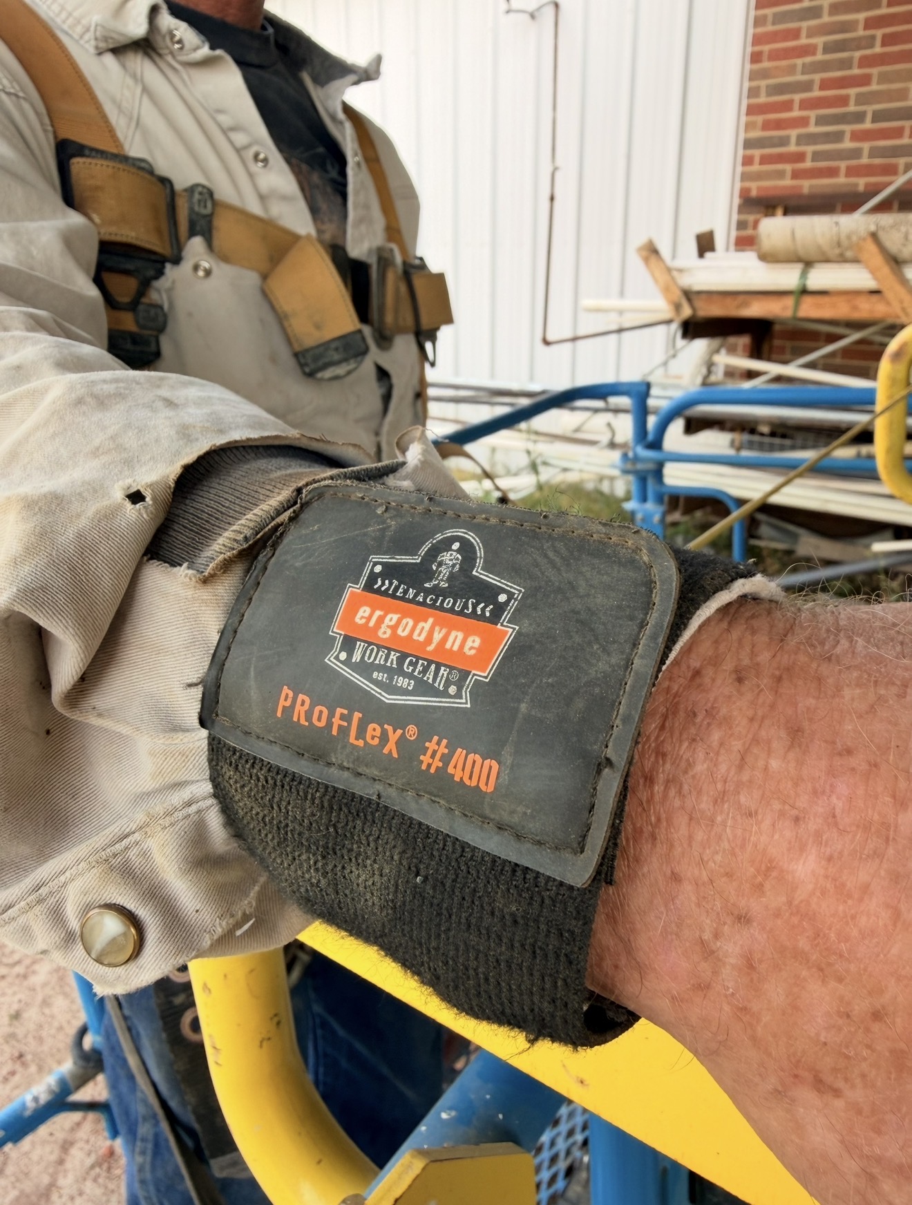 Close-up of an Ergodyne ProFlex wrist support worn by a tradesperson on a job site